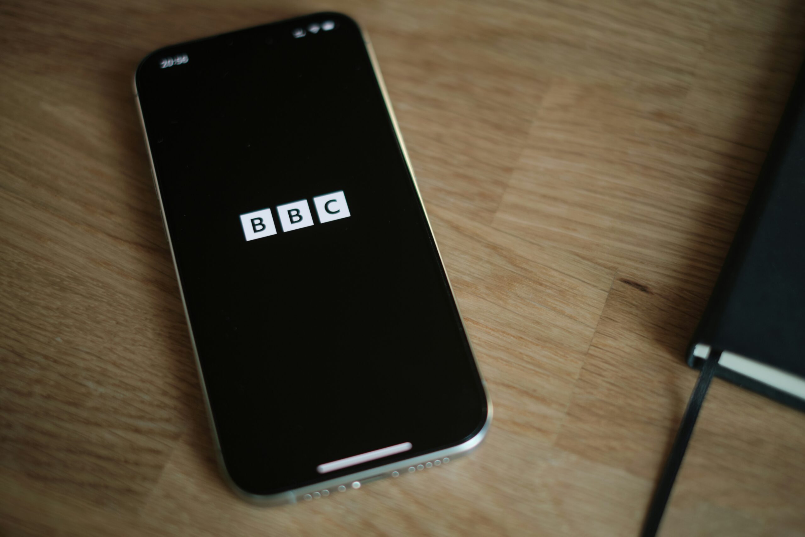 Smartfon z logotypem BBC i terminarz, symbolizujące Brytyjskie ikony BBC oraz naukę języka angielskiego w domu.